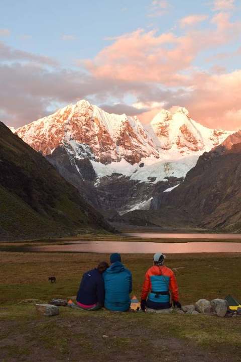 Sunset over the Cordillera Huayhuash, travellers sitting by the lake